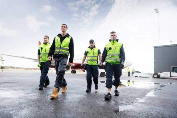 Airport ground staff wearing safety vests recruited by Al Saqib Recruitment Agency