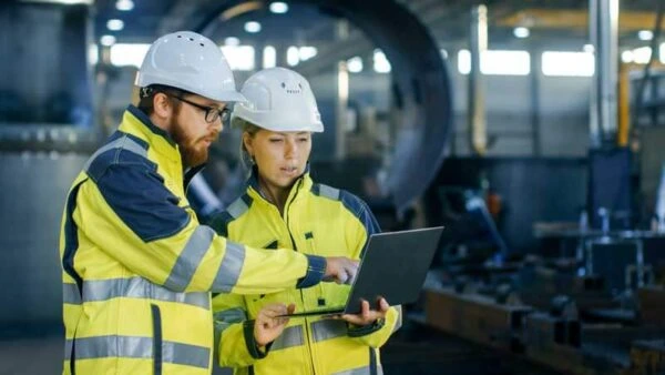 Industrial engineers reviewing technical operations on a laptop, representing Alsaqib recruitment services.